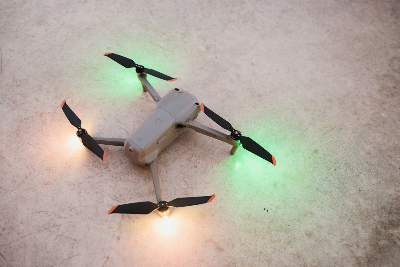 Close-up of a drone on the ground with glowing lights, showcasing modern technology.